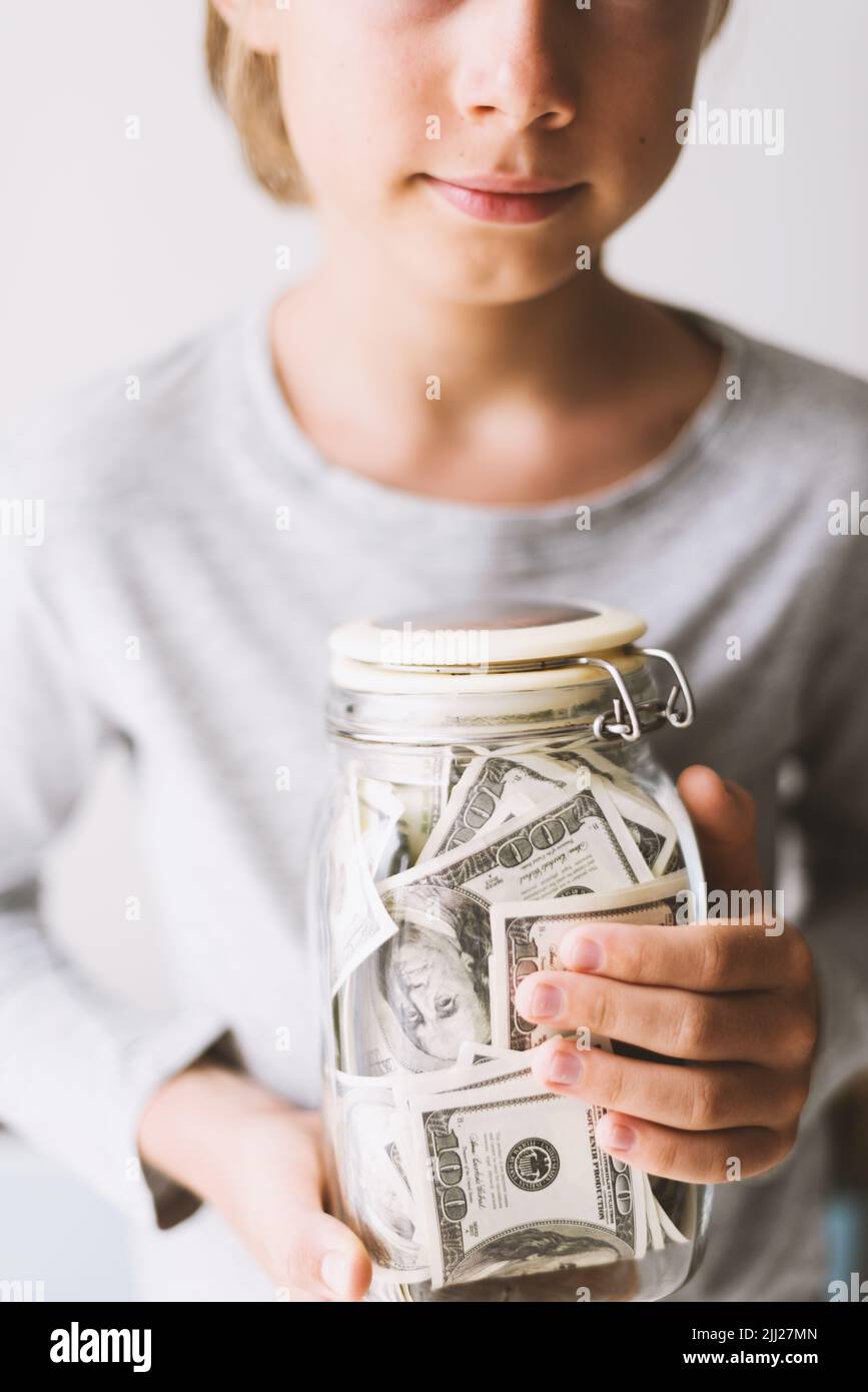 Kid save money. Put money in a piggy bank Stock Photo Alamy