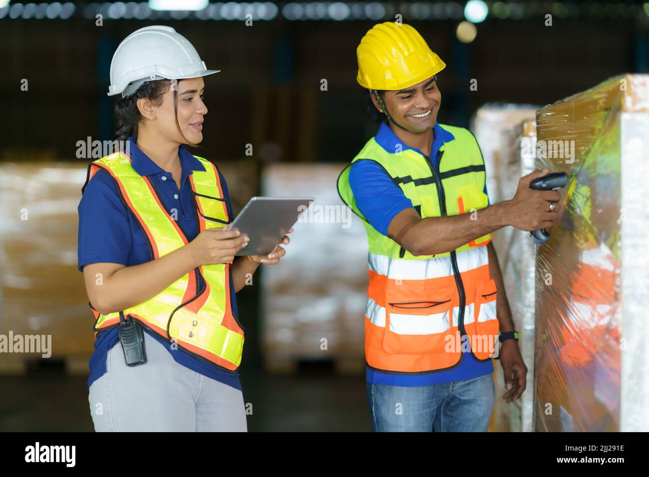 Asian couple warehouse workers checking shipment status on digital tablet computer prepare for delivery to customer. Employees teamwork. Stock Photo