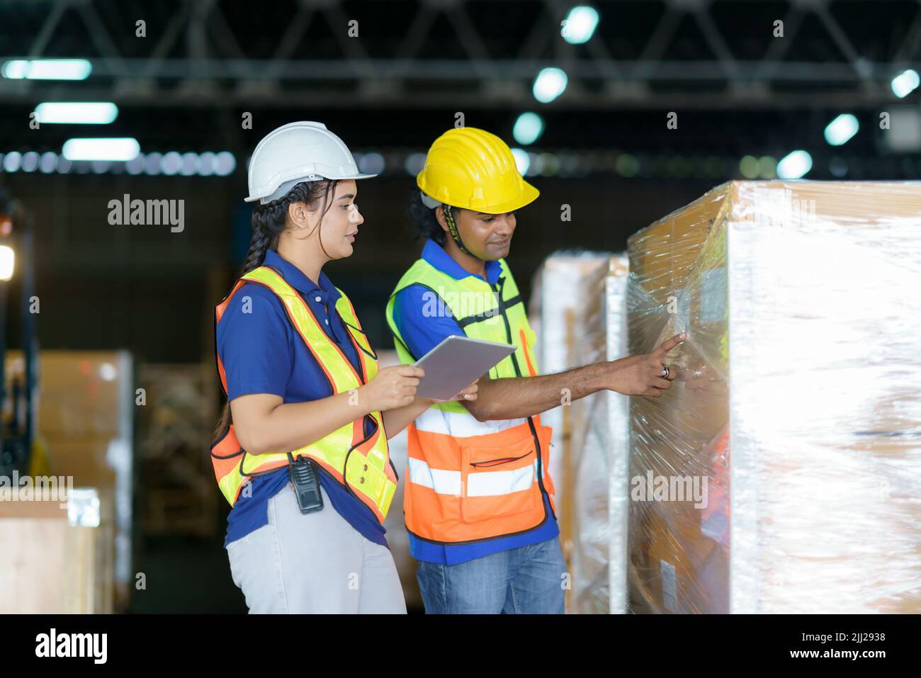 Asian couple warehouse workers checking shipment status on digital tablet computer prepare for delivery to customer. Employees teamwork. Stock Photo