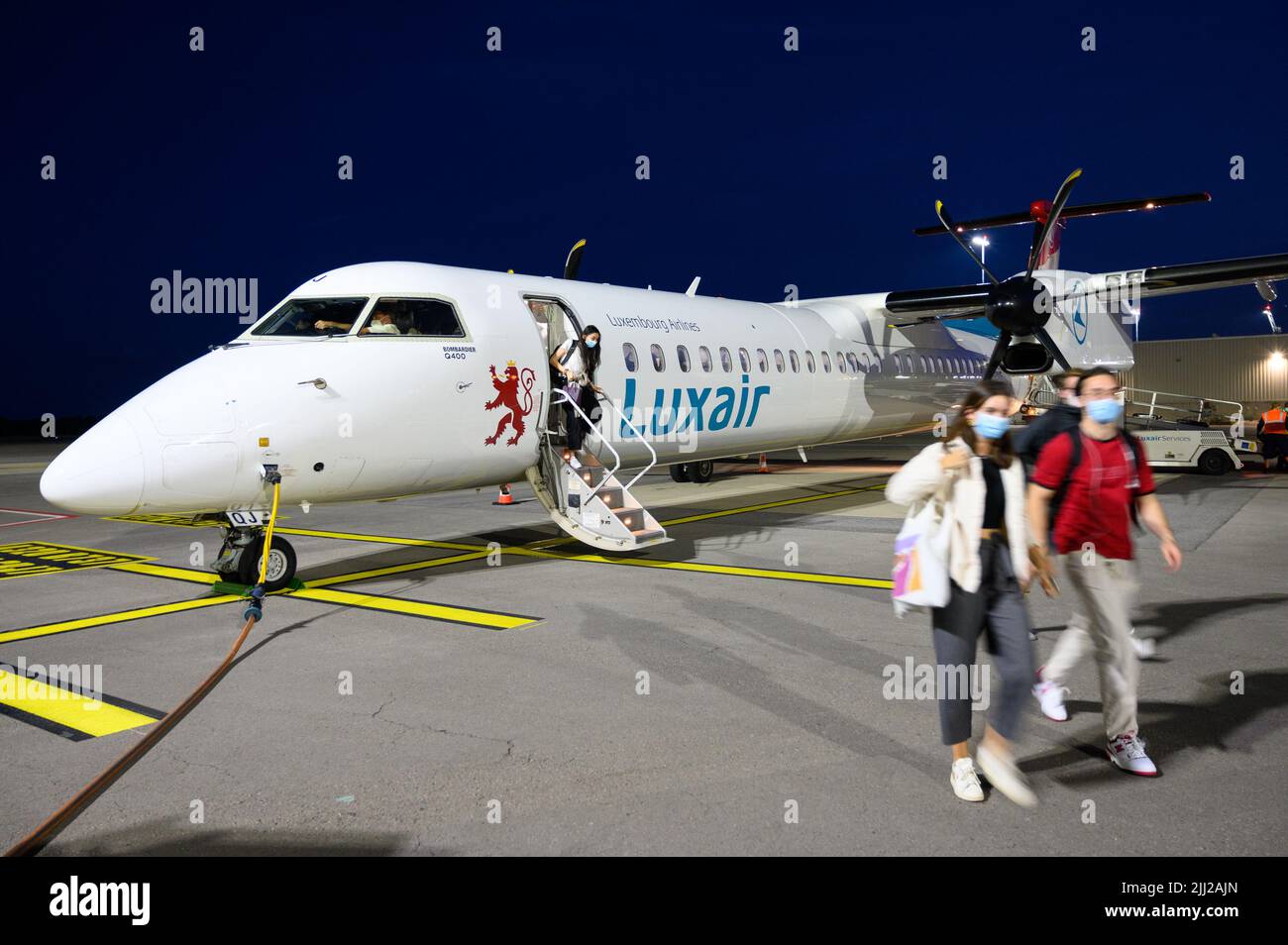 Passengers getting off a landed Luxair (Luxembourg Airlines) airplane (Bombardier Q400) at the Luxembourg Airport. Stock Photo