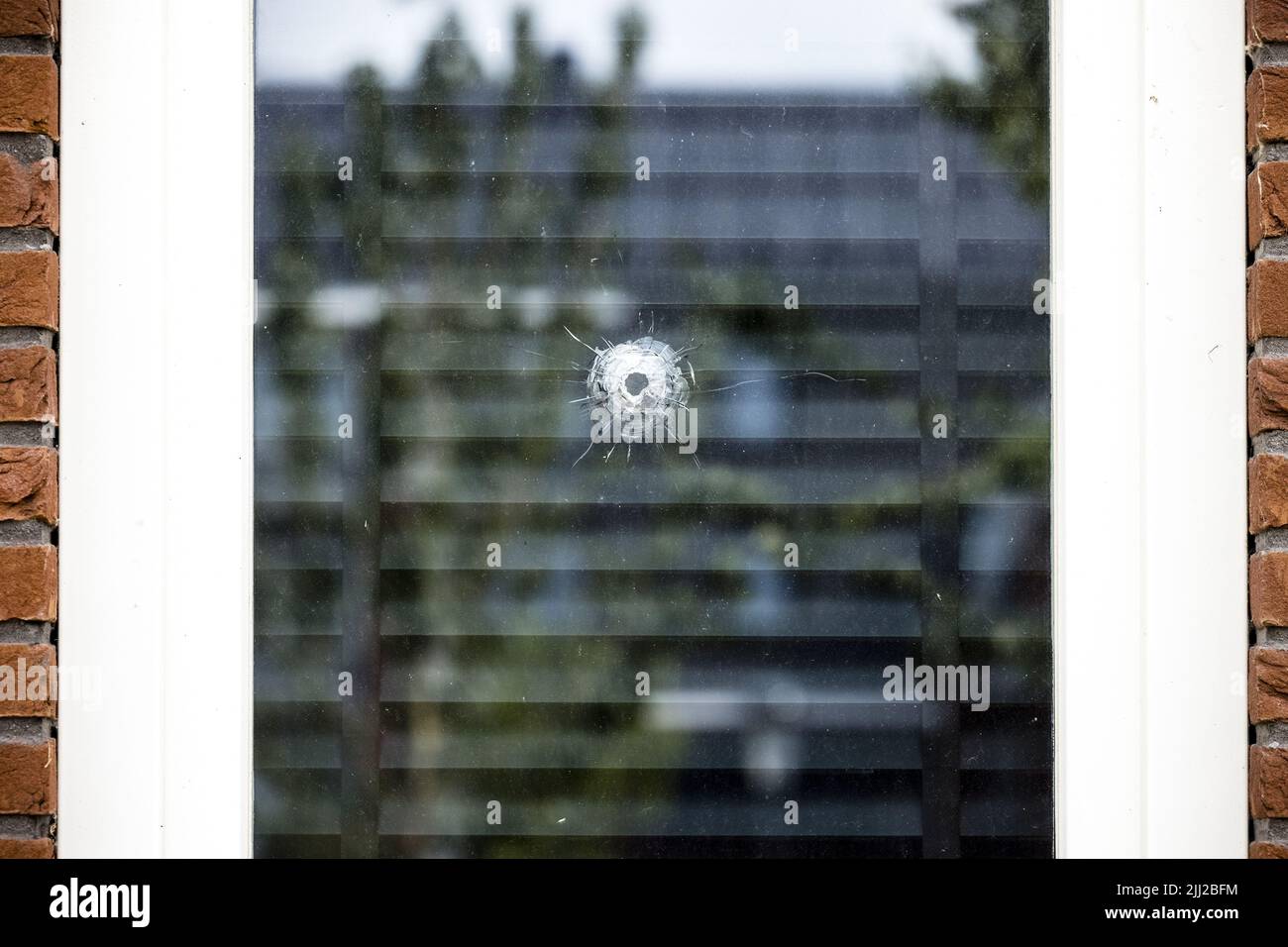 2022-07-22 17:05:31 OSS - A bullet hole in a window on the Veekraal before a shooting took place. For the fourth time in a row, a house in a residential area in Oss has been shot at. The police suspect that there is a relationship between the houses that were shot at and the people who live there. ANP ROB ENGELAAR netherlands out - belgium out Stock Photo