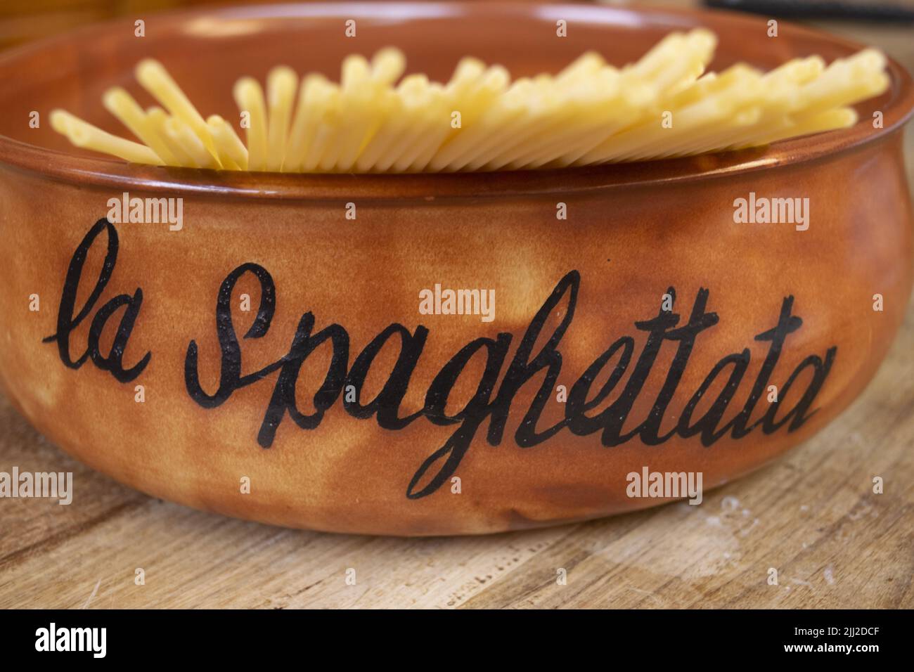 earthenware pan with raw spaghetti inside and the word spaghetti on one side Stock Photo