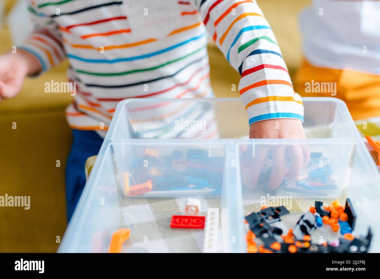 Kid collects robot from plastics details and programmed on tablet, robotics. Stock Photo
