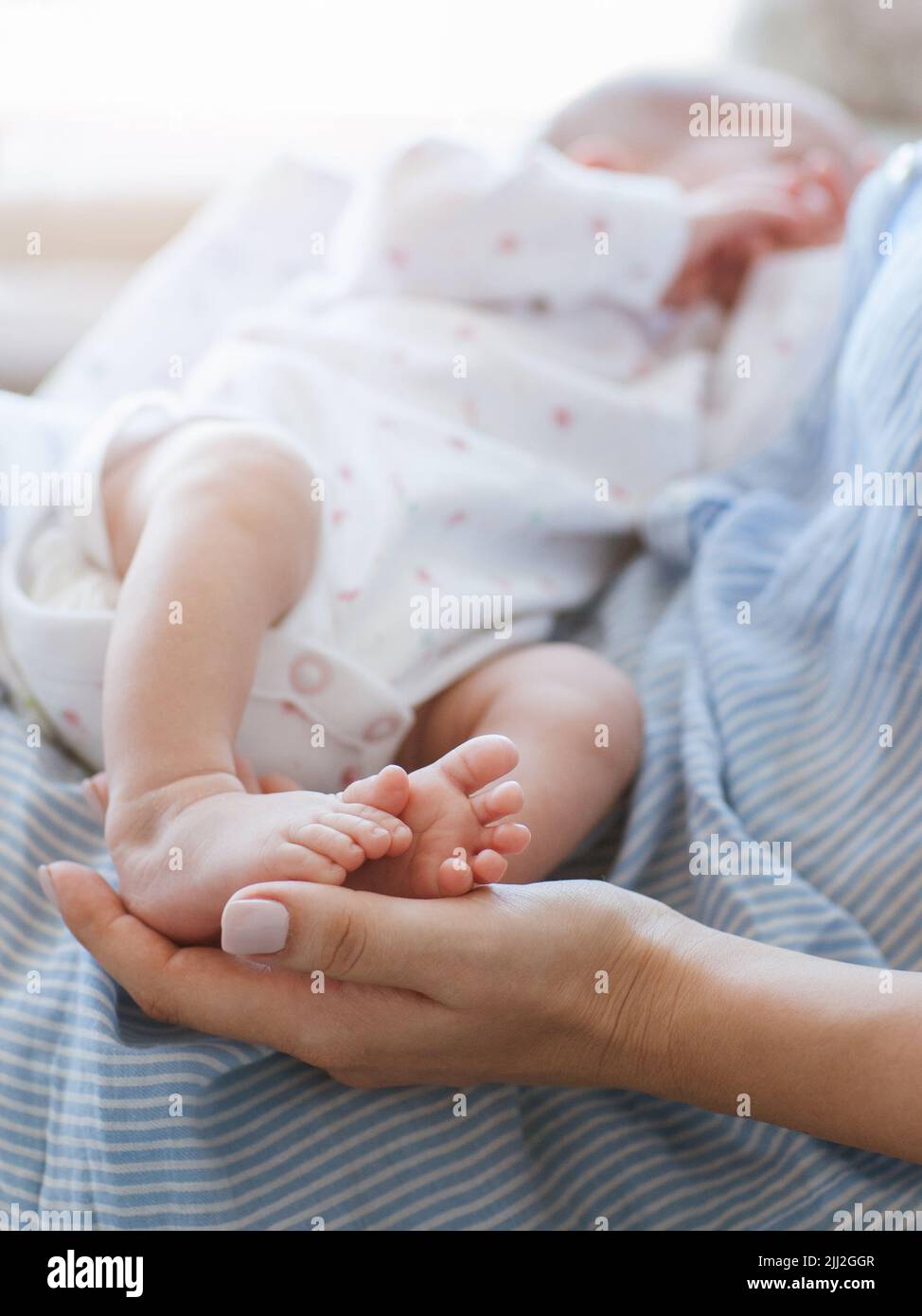 mother holds the legs newborn baby Stock Photo Alamy