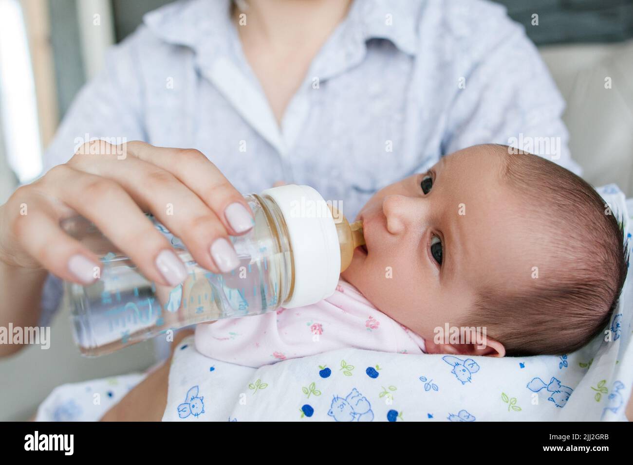 mom gives the newborn baby water from a bottle Stock Photo Alamy