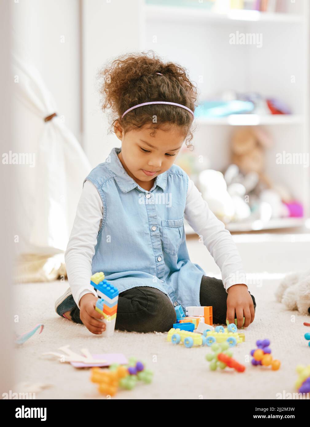 Moments are more valuable now than years that are gone. a little girl playing at home. Stock Photo
