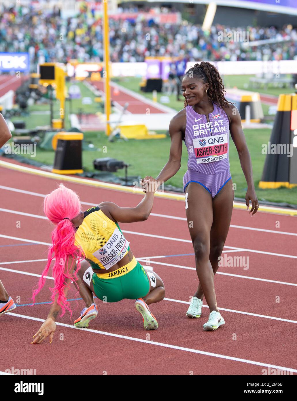 Dina AsherSmith (GB&NI) helping ShellyAnn FraserPryce (JAM) of the