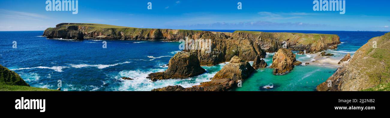A panorama of the rugged coastal cliff scenery and pristine turquoise waters around the island of Uyea in Northmavine, Shetland, UK. Stock Photo