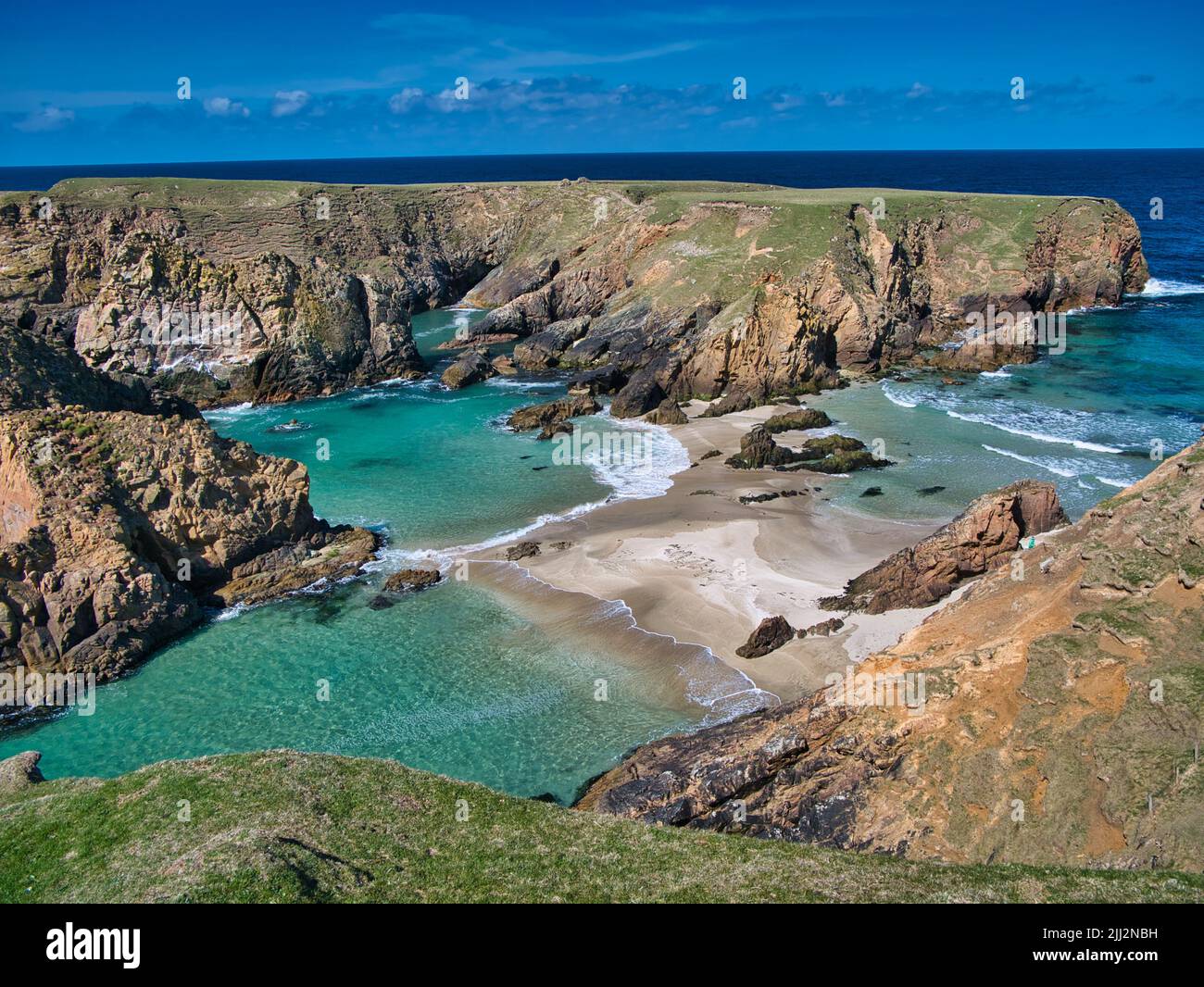 The rugged coastal cliff scenery and pristine turquoise waters around the island of Uyea in Northmavine, Shetland, UK. Taken on a sunny day. Stock Photo