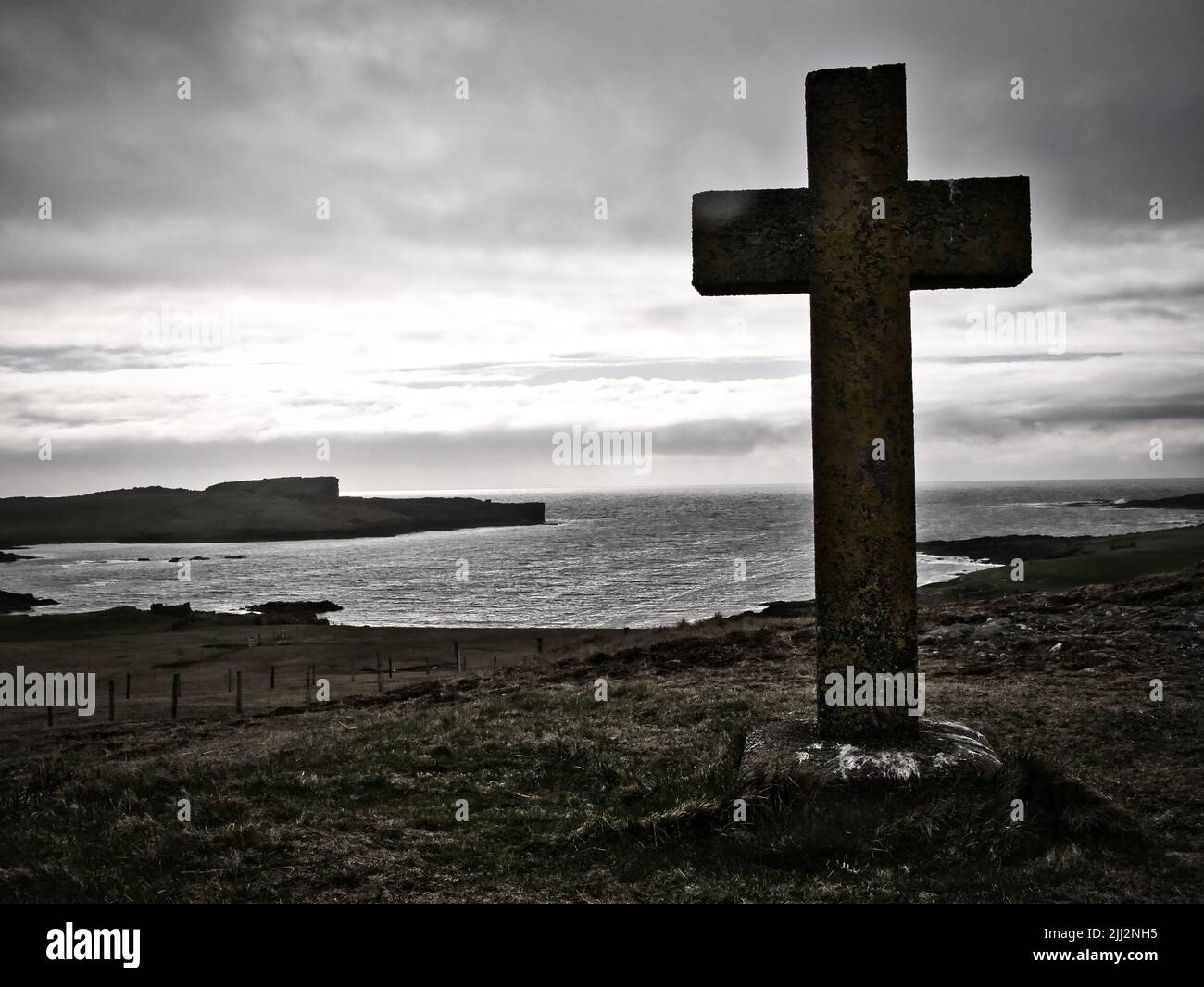 A stone cross (1927) at Stenness erected by the Commissioners for Northern Lighthouses to mark where supplies for the Eshaness Lighthouse were landed Stock Photo