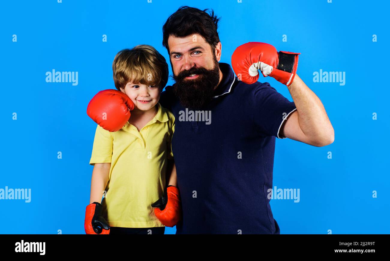 Little child boy in boxing gloves with coach. Trainer with kid boxer stand together. Sport lifestyle. Stock Photo