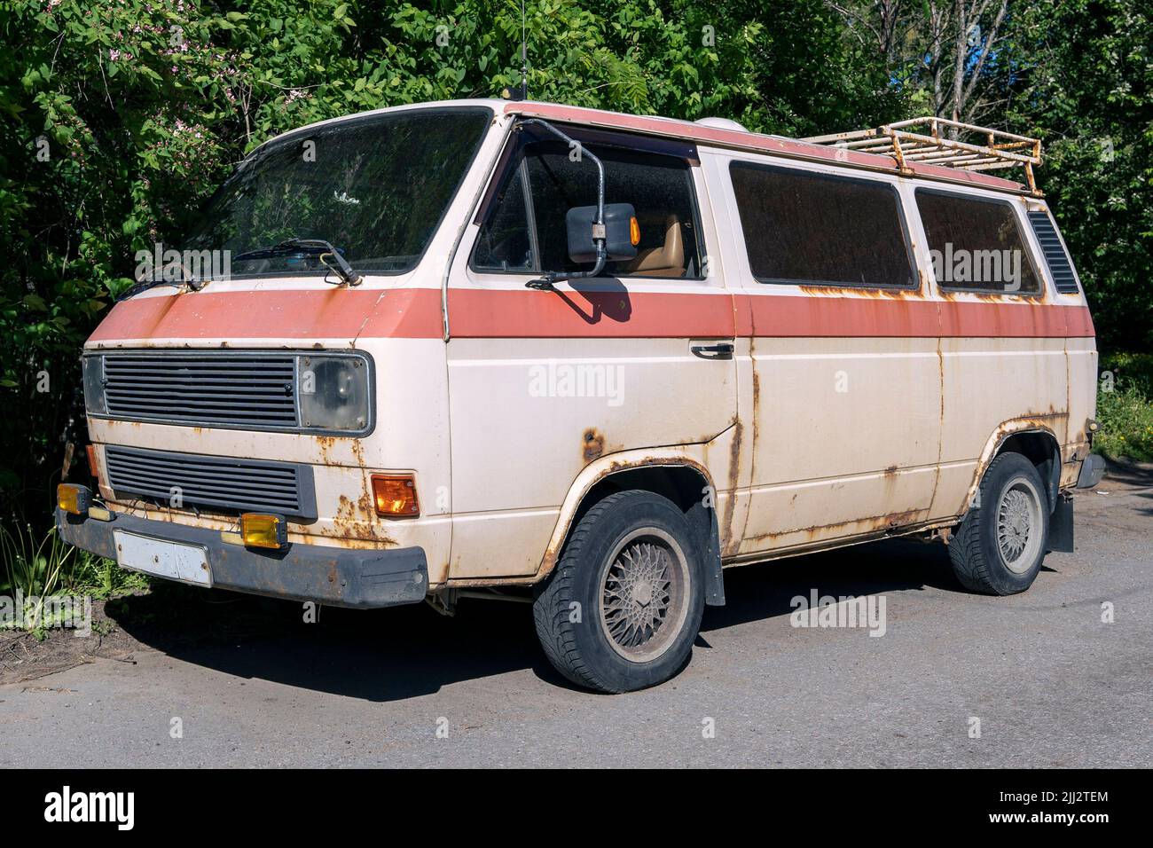 an old vintage rusty minibus standing in the yard. hippie culture Stock Photo