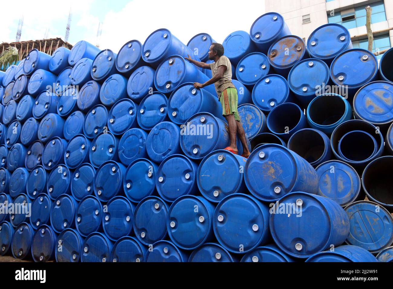 worker seen washing empty oil drums for recycling at a warehouse in Khulna outstrick Dhaka