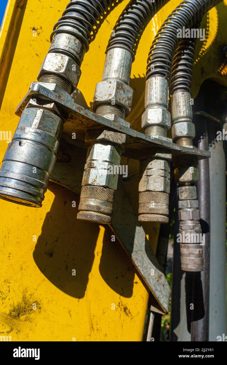 Various adapters for hydraulic hoses on the bucket arm of a wheel loader for attaching different