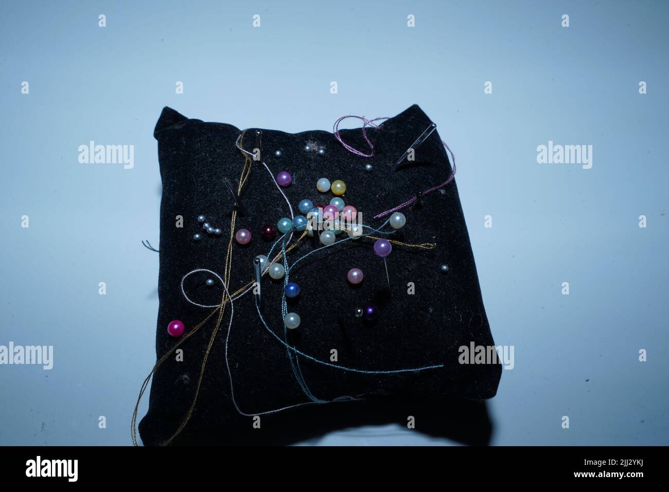 Pins and threads on the black pad Stock Photo Alamy