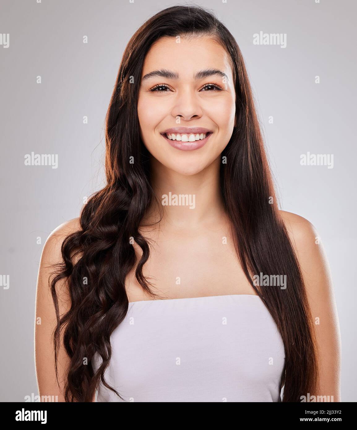 Which style should I go with today. a woman posing with half straightened and half curled hair. Stock Photo