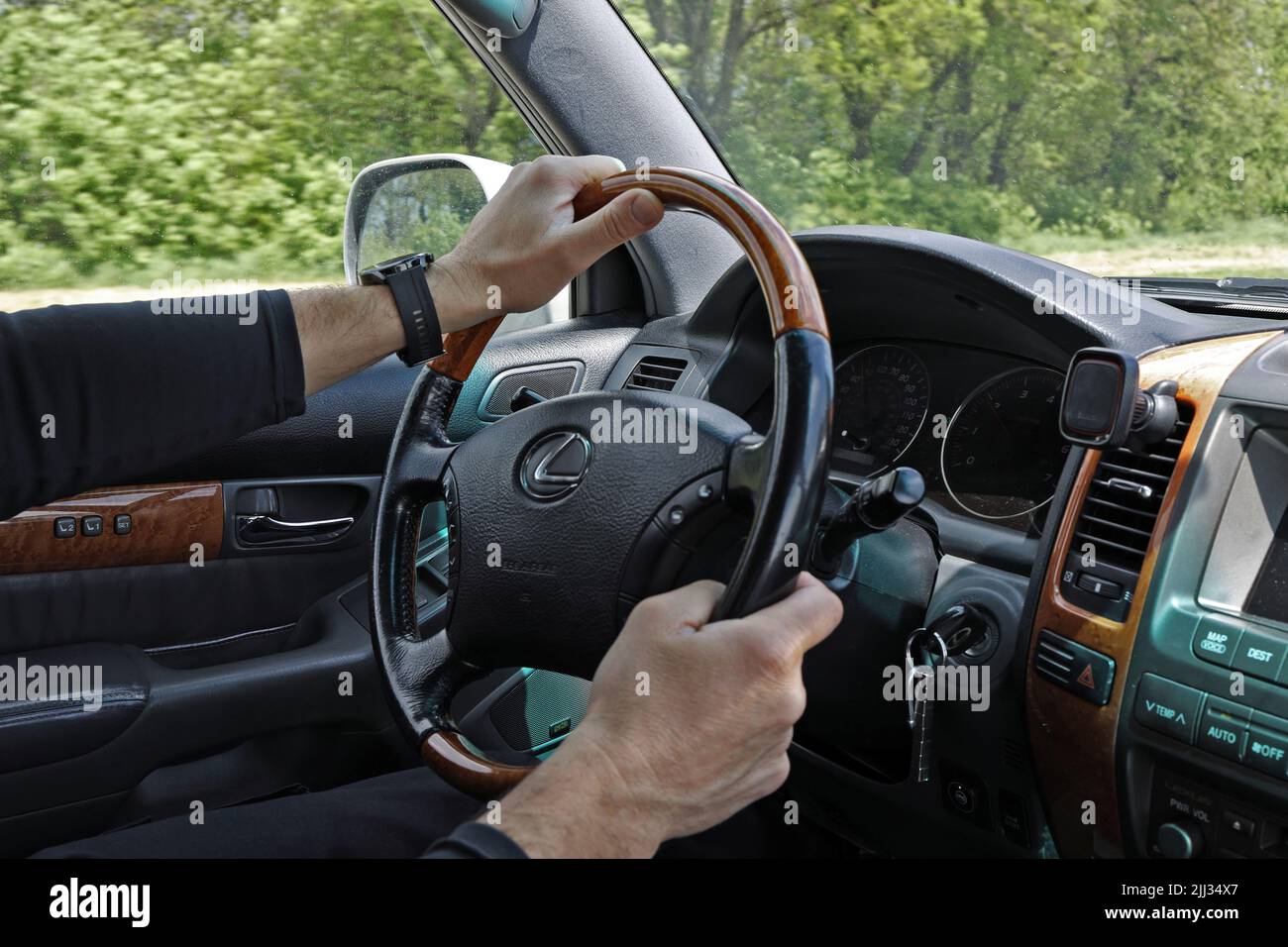 Male hands on the steering wheel of a Lexus GX470