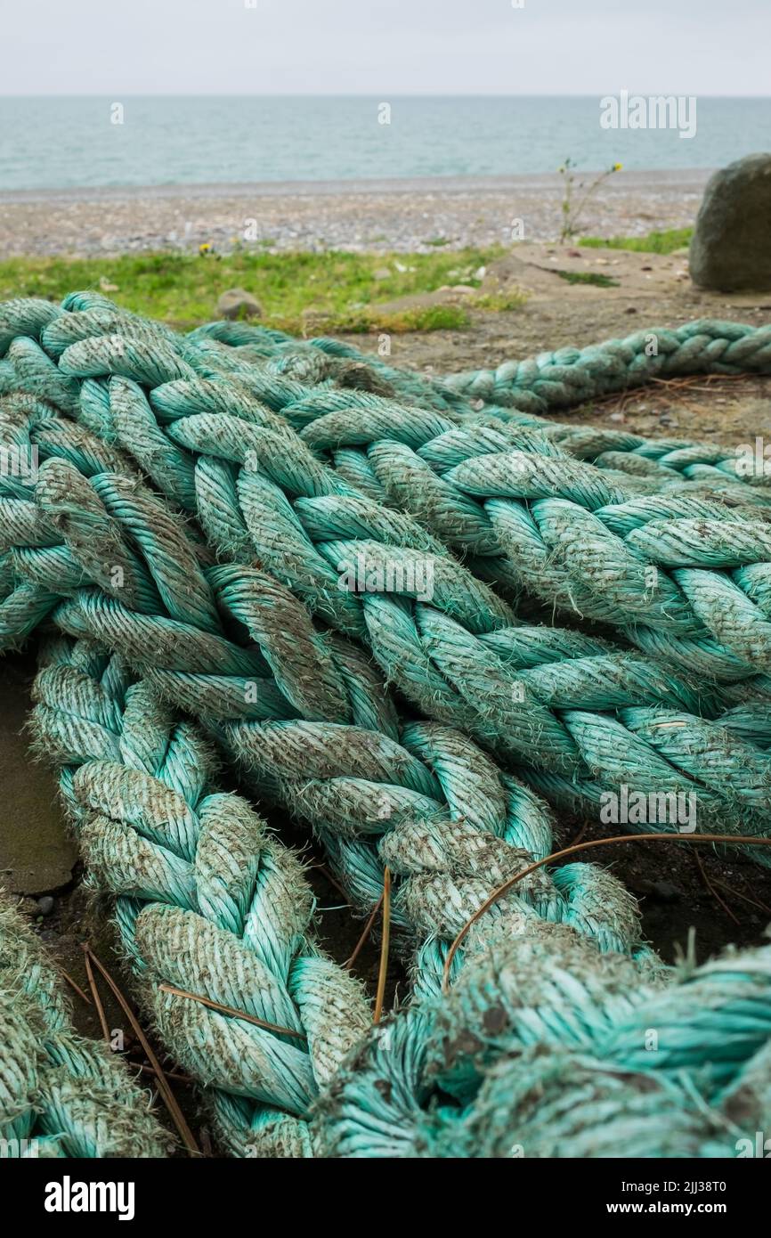 Old rope on the beach. Vertical orientation. Stock Photo