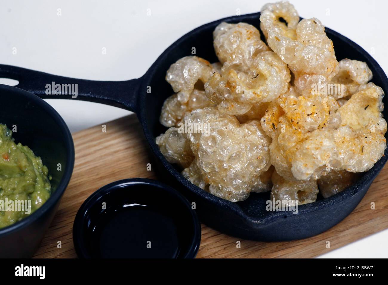 sun dried and deep fat fryer crispy pork skin known as chicharon in a serving dish, filipino delicacy food Stock Photo
