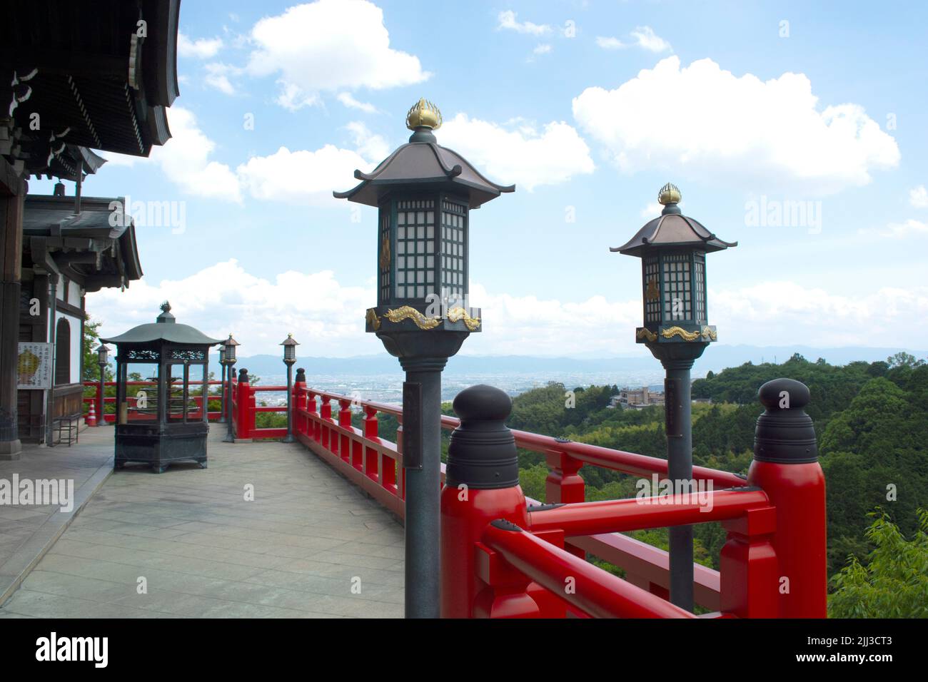 Lanterns and fence in front of temple - shrine with tree foliage in ...