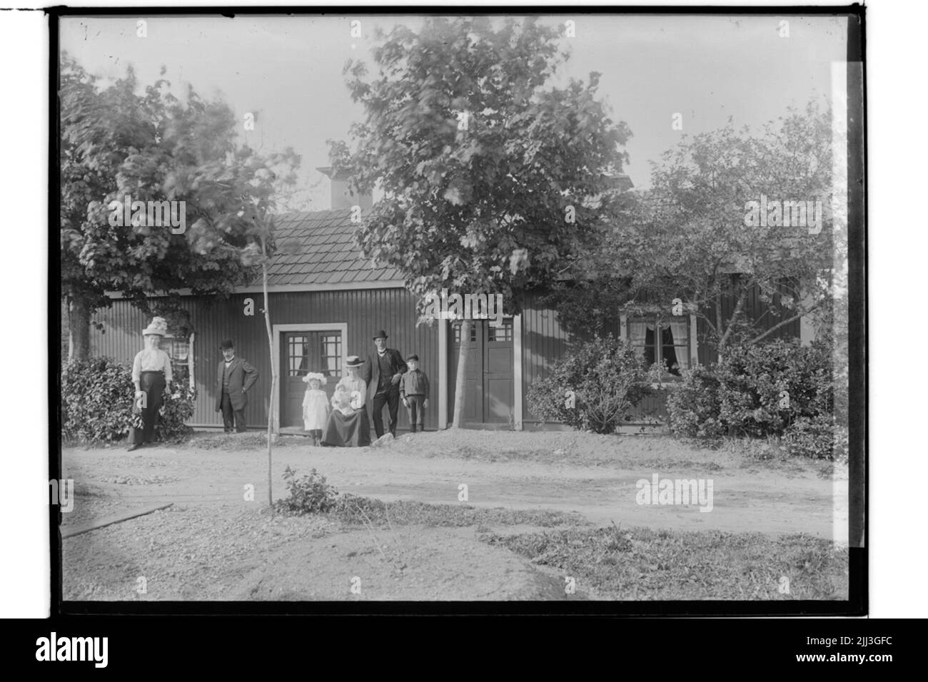 One story double house, 7 people in front of the building. Karl Thorén