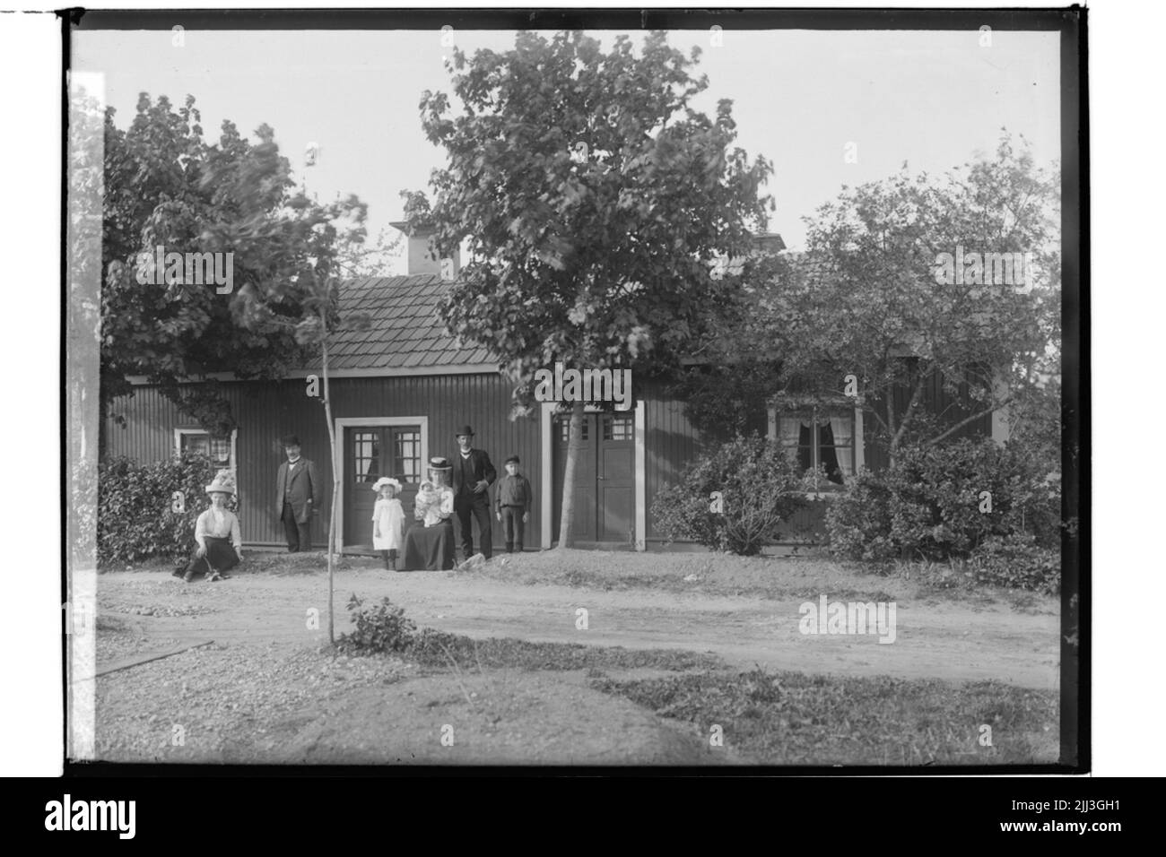 One story double house, 7 people in front of the building. Karl Thorén