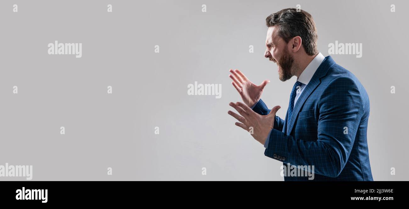 Distressful experience. Man face portrait, banner with copy space. Business man in suit, isolated studio background. Angry boss scream making wide Stock Photo