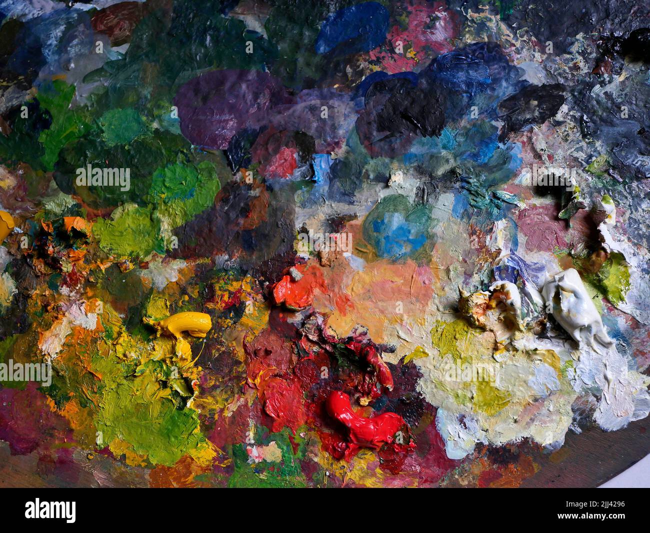 AJAXNETPHOTO. 2021. WORTHING, ENGLAND. - COLOUR PALETTE - A PAINTER'S WOODEN PALETTE COVERED IN A MESS OF OIL-PAINT COLOURS.PHOTO:JONATHAN EASTLAND/AJAX REF:GX9 211209 2464 2 Stock Photo