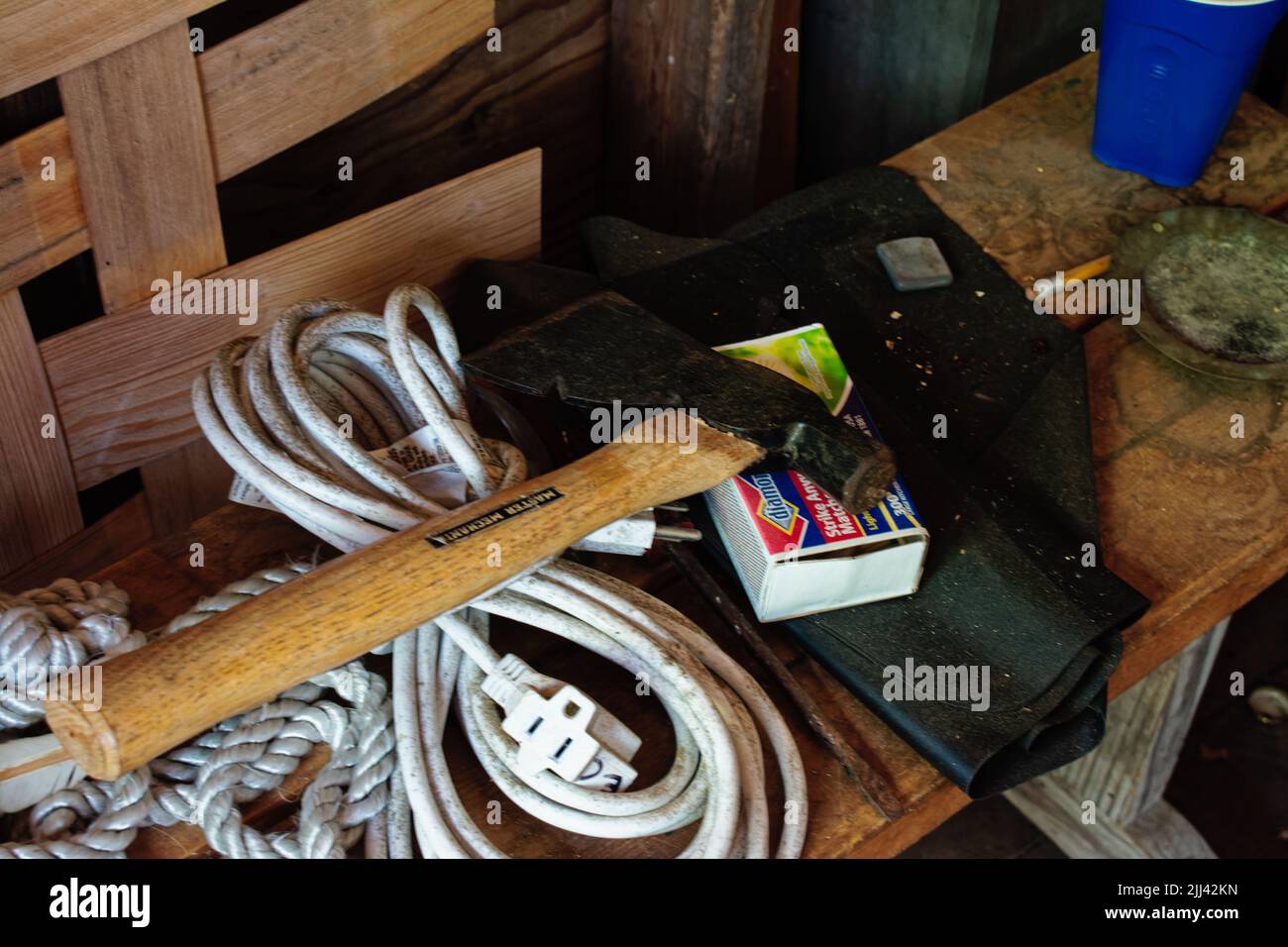 A murder kit containing a hatchet, rope, electrical wire, matches, and lawn bags sits on bench in one of the sheds at the Essex Shipbuilding Museum Es Stock Photo