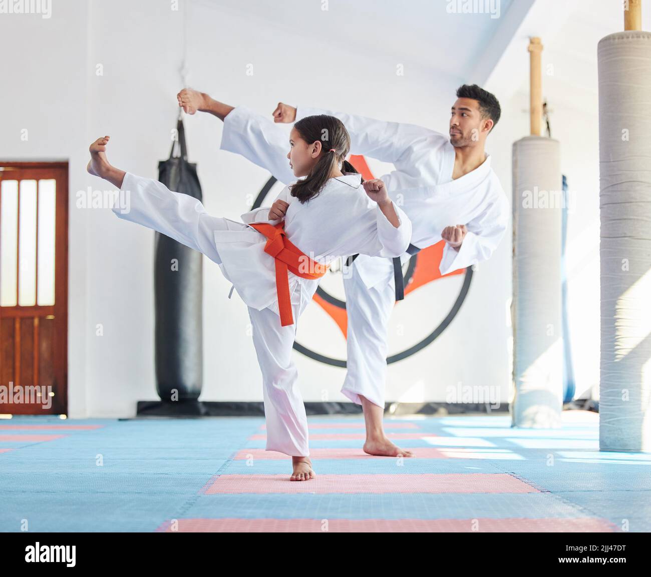 Where the greatest warriors are born. a young man and cute little girl practicing karate in a studio. Stock Photo