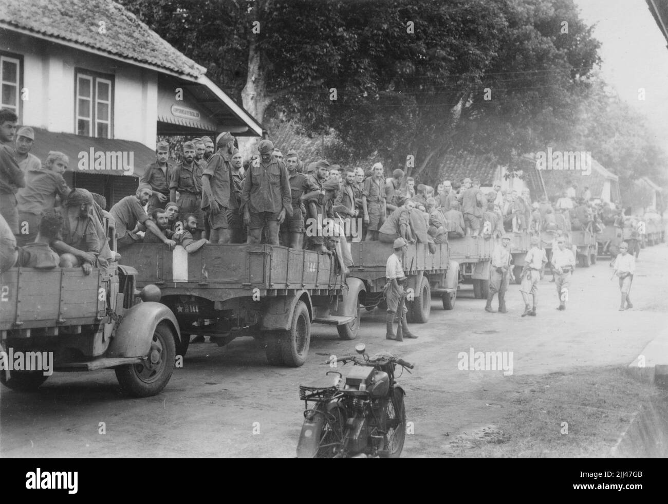 Pacific War, 1941-1945. After their capitulation to the invading Imperial Japanese 16th Army, Royal Netherlands East Indies Army (KNIL) troops are loaded onto trucks and await transport to prisoner-of-war camps, Dutch East Indies, circa March 1942. Stock Photo