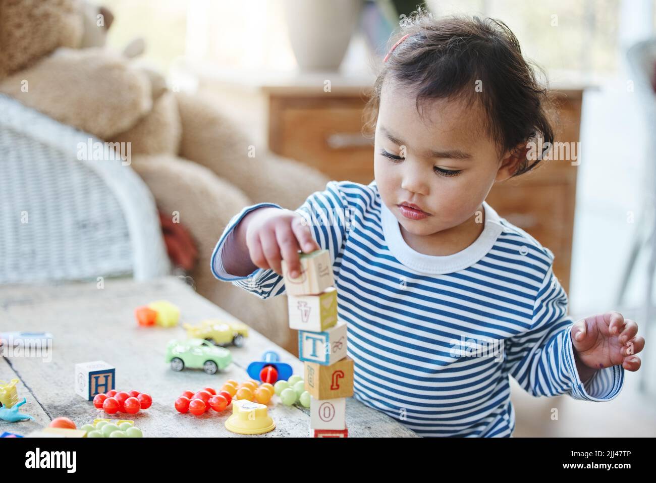 Keeping her little hands busy. an adorable little girl playing with her toys at home Stock Photo