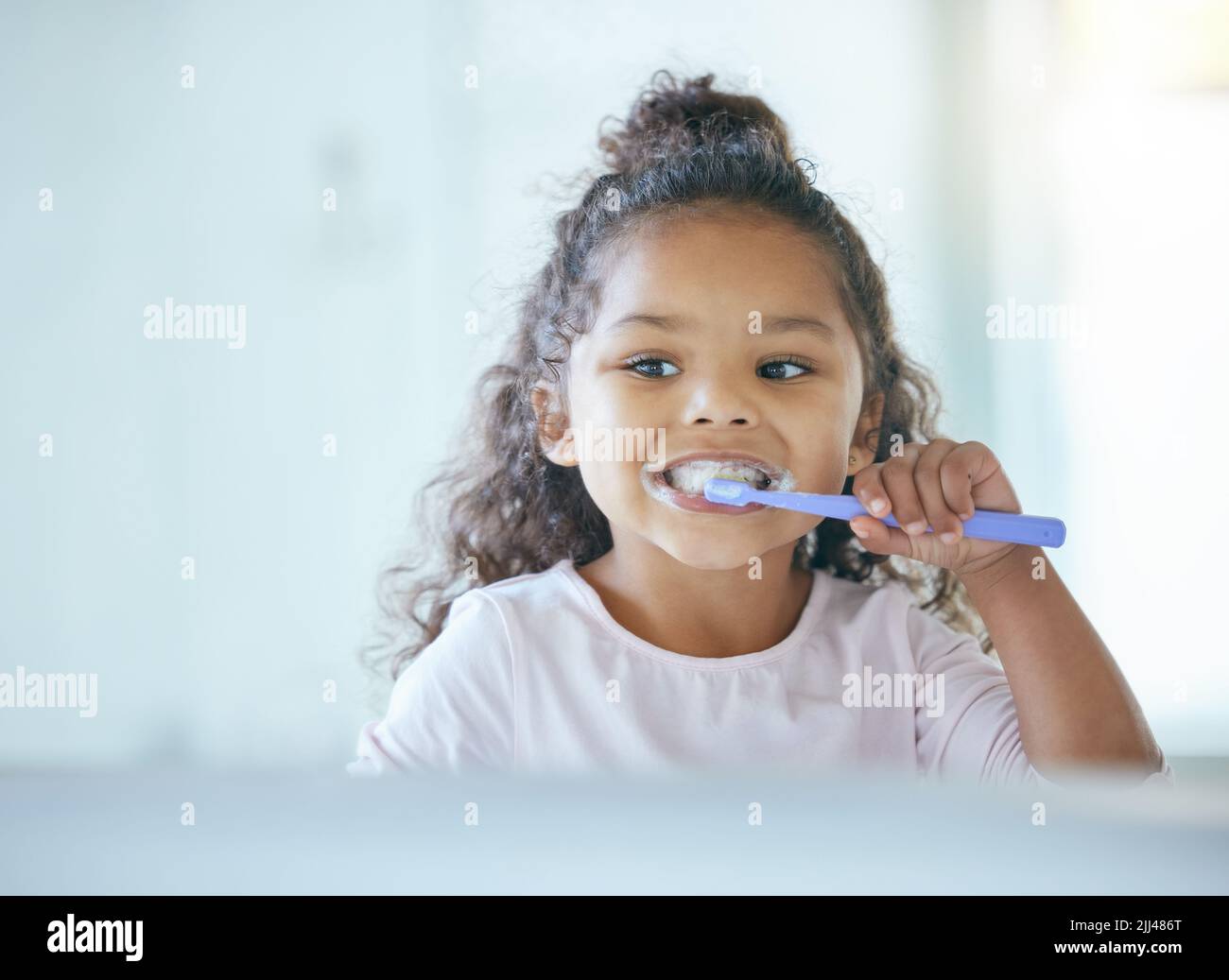 Taking good care of my teeth. a little girl brushing her teeth in a bathroom at home. Stock Photo