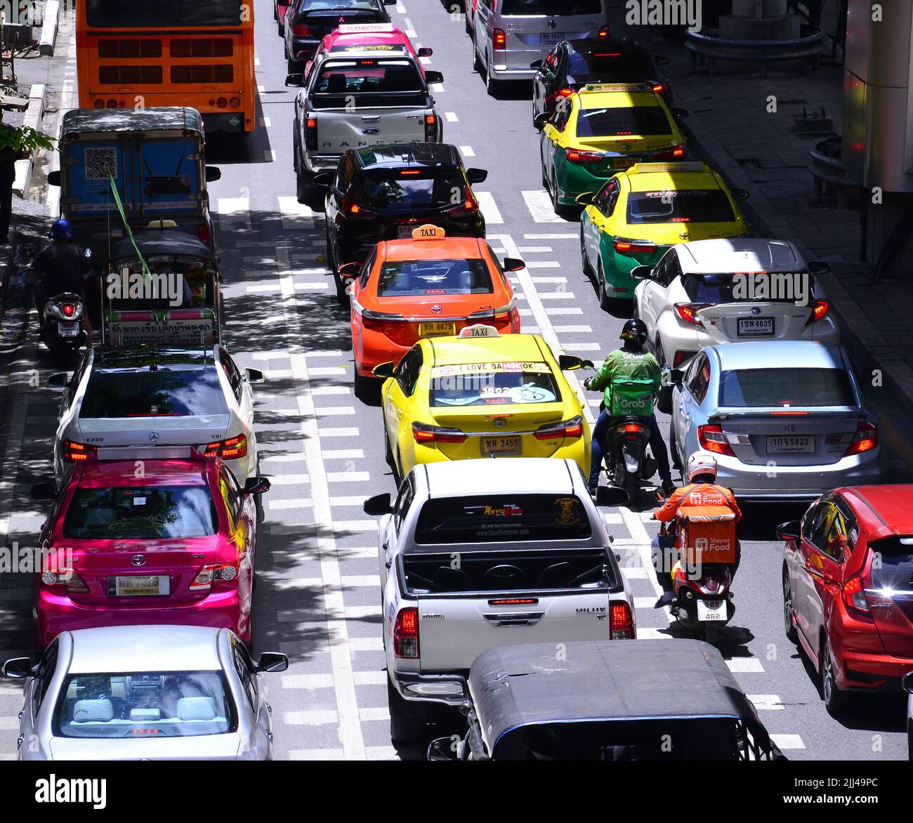 Traffic jam of cars, motorbikes and a bus on Silom Road, Bangkok, Thailand, Asia, as drivers of vehicles struggle to make progress in busy daytime traffic. Stock Photo