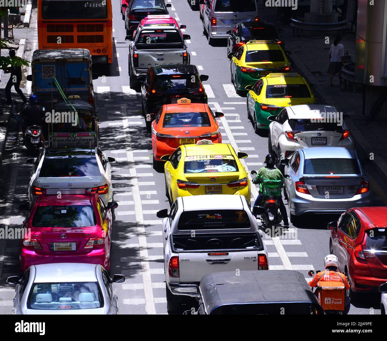 Traffic jam of cars, motorbikes and a bus on Silom Road, Bangkok, Thailand, Asia, as drivers of vehicles struggle to make progress in busy daytime traffic. Stock Photo