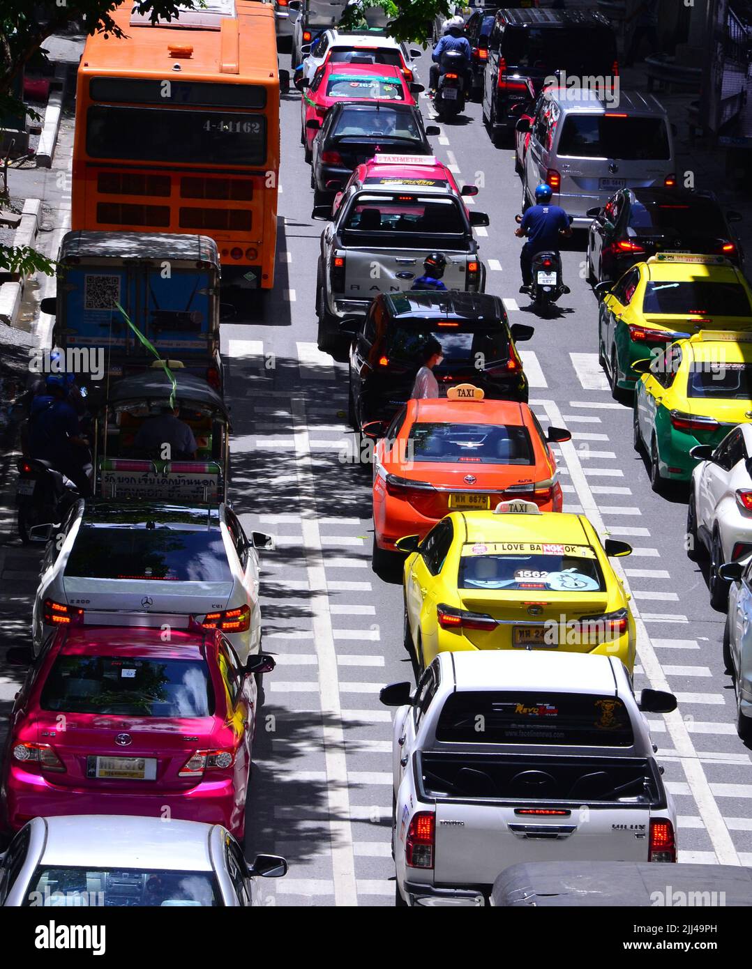 Traffic jam of cars, motorbikes and a bus on Silom Road, Bangkok, Thailand, Asia, as drivers of vehicles struggle to make progress in busy daytime traffic. Stock Photo