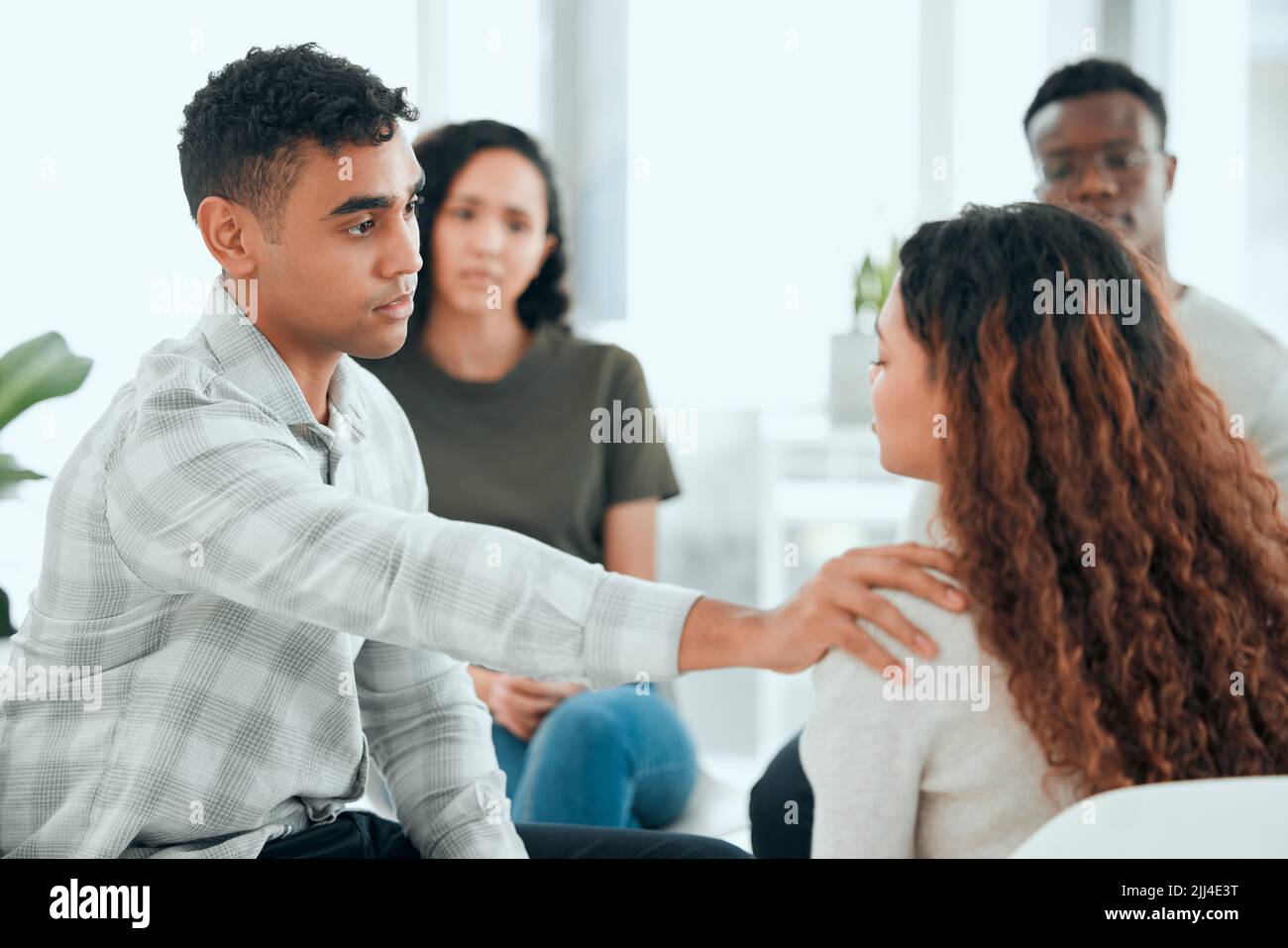 Were here for you. a handsome young man sitting and comforting a member of his support group. Stock Photo