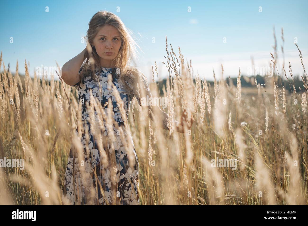 Beauty Romantic Girl Outdoors. Beautiful Teenage Model girl Dressed in Casual Dress on the Field in Sun Light. Glow Sun, Sunshine Stock Photo