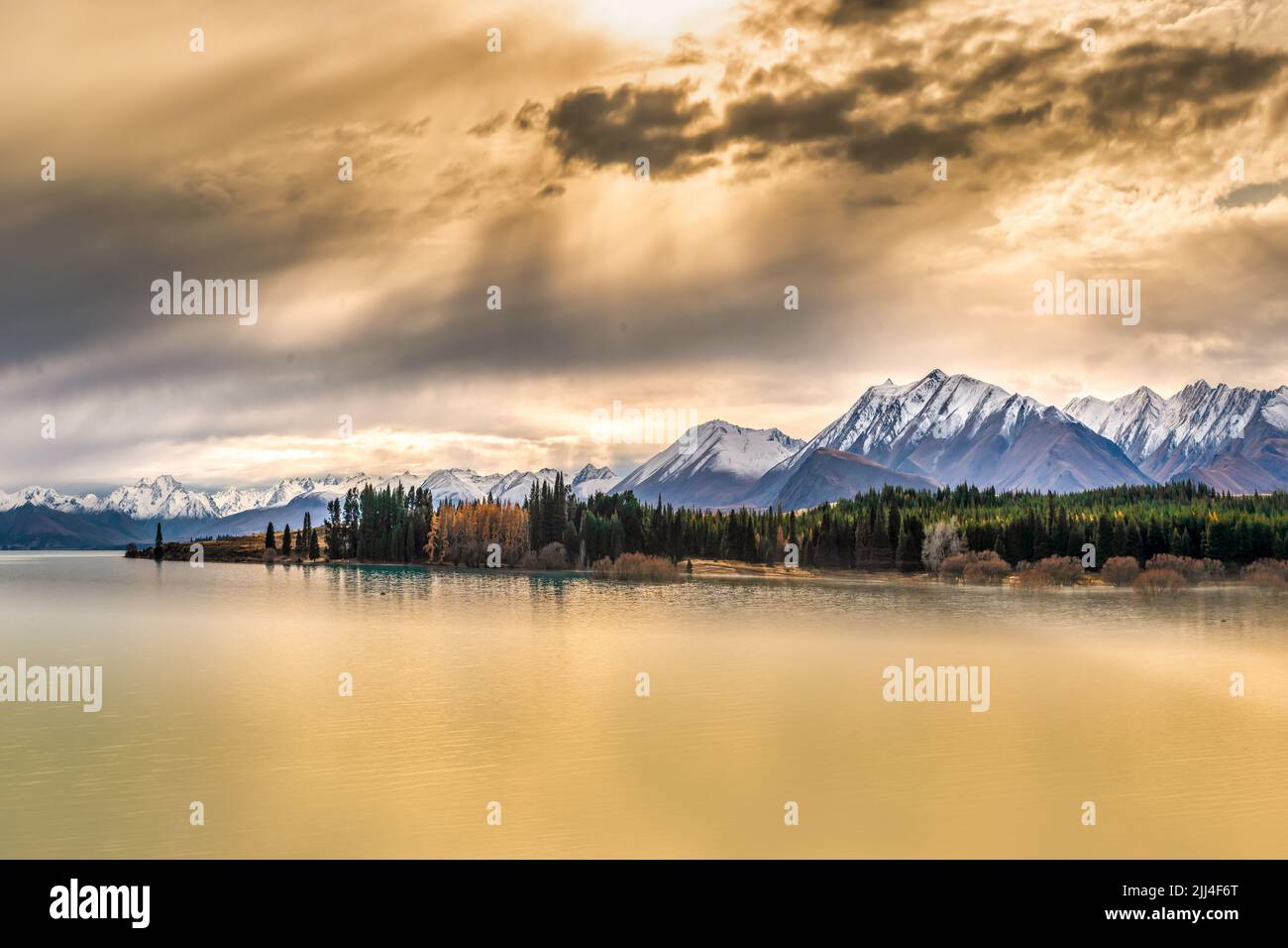The snow capped Southern alps mountain range at Lake Tekapo under eerie weather conditions Stock Photo