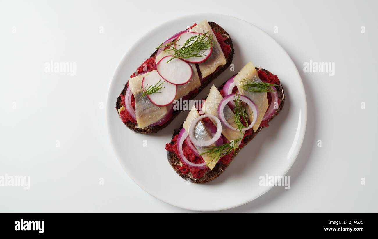 Danish open sandwich Smorrebrod on dark rye bread with herring, salmon
