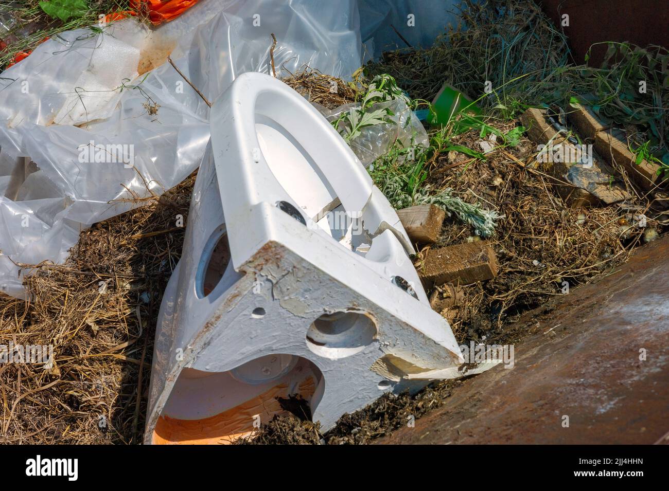 old cracked toilet bowl thrown into a garbage container Stock Photo Alamy