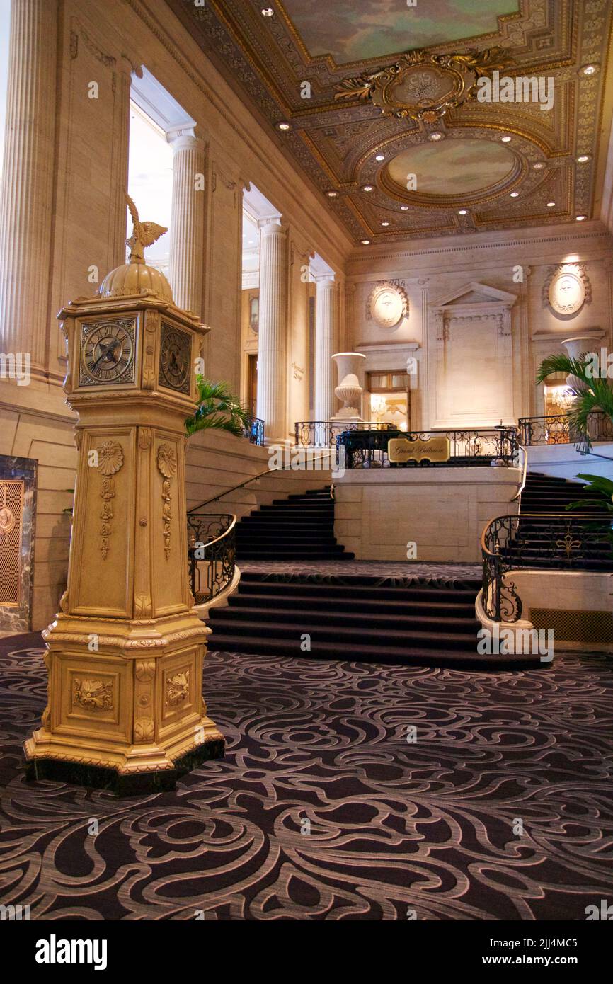 CHICAGO, ILLINOIS, UNITED STATES - May 12, 2018: Large gold grandfather clock in lobby of luxury hotel on Michigan Avenue Stock Photo
