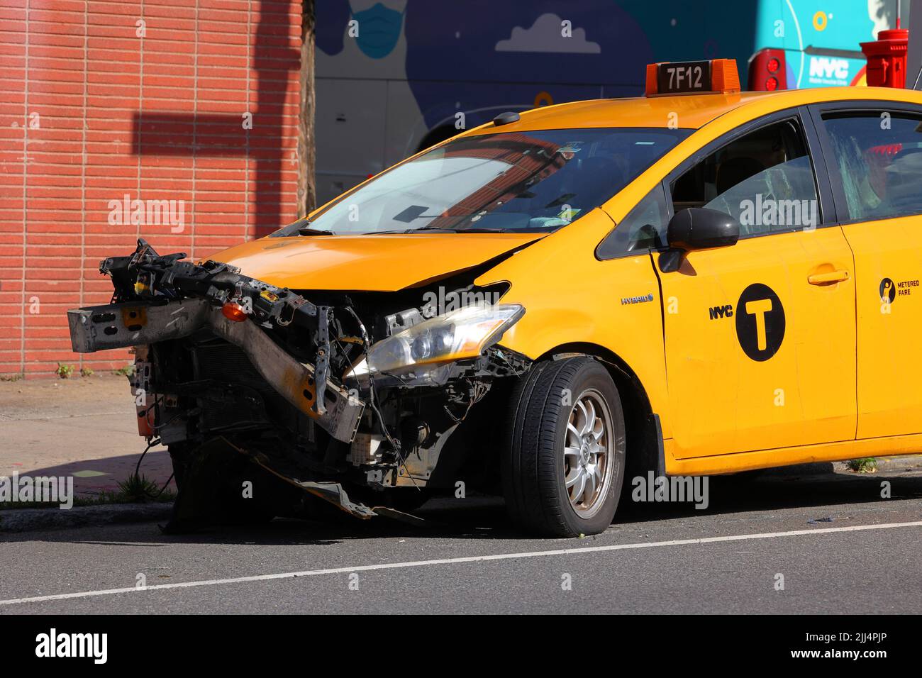 A totalled NYC Taxi with front end damage. A New York City Yellow Taxi crash after a head on collision. Stock Photo