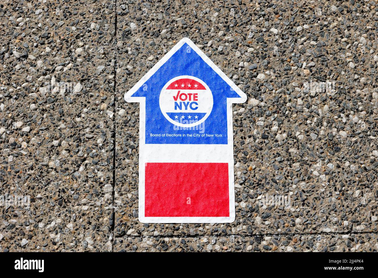 A NYC Board of Elections Vote NYC arrow sticker on the ground directs people to a polling site. Stock Photo
