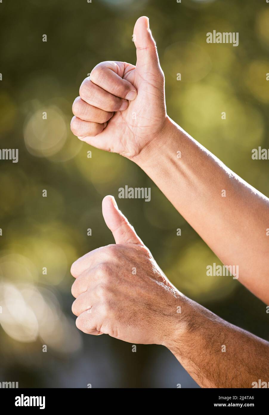 Youve got my stamp of approval. two unrecognisable men showing thumbs up outdoors. Stock Photo