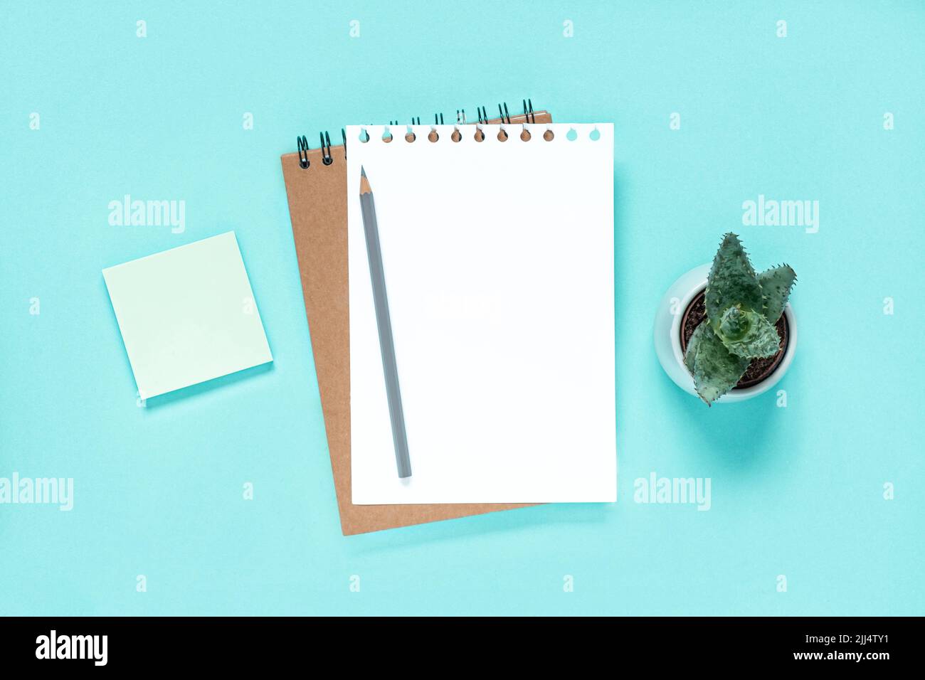 Notebook with pencil. School notebook on light blue background, spiral ...