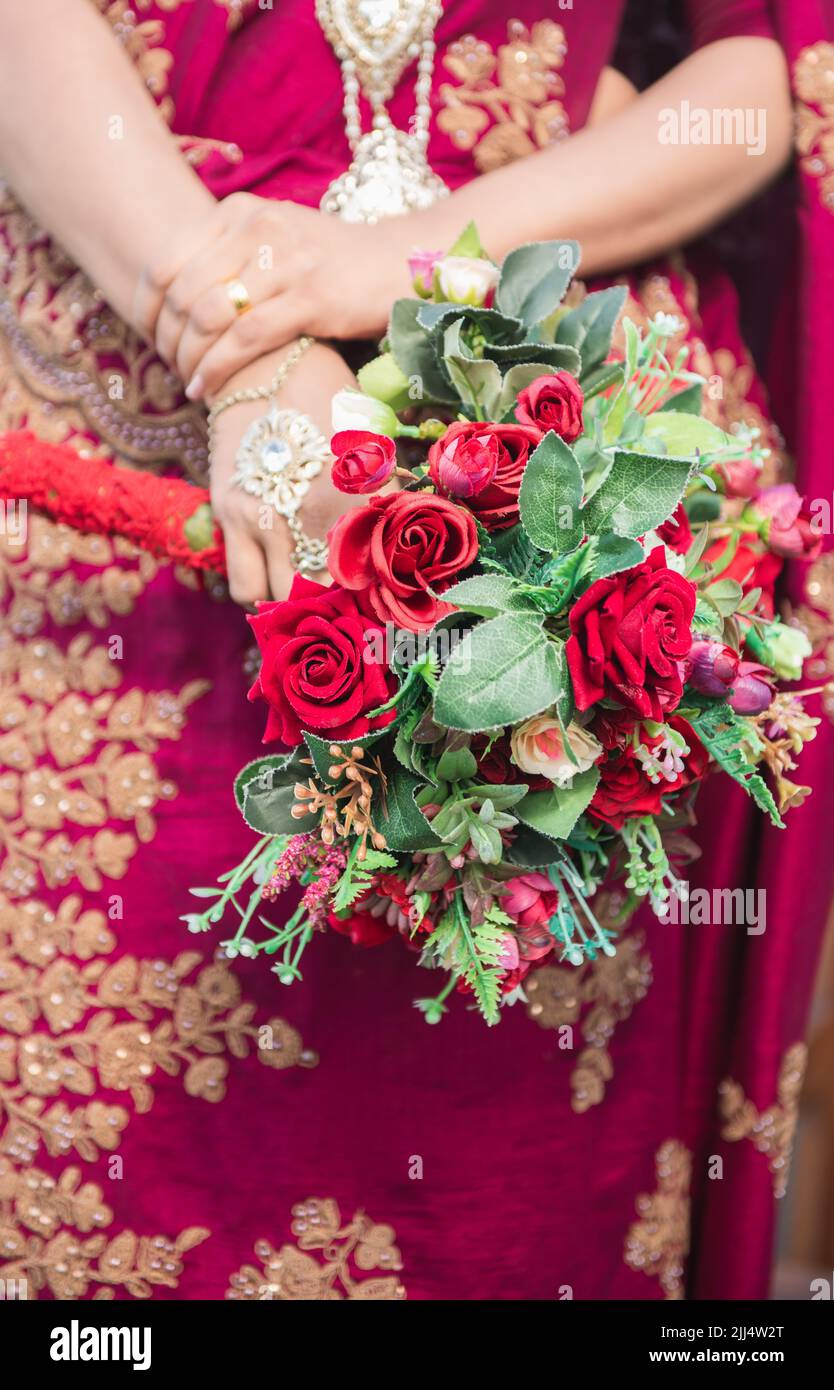 Bride holding a rose flower bouquet close-up photo, Beautiful red