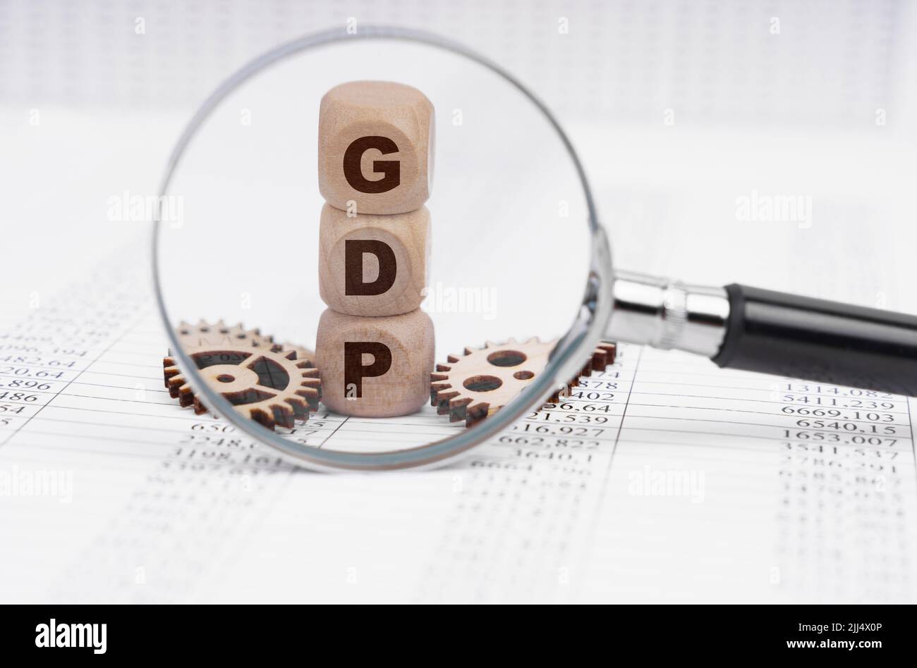 Business concept. There is a magnifying glass on the documents that points to the cubes with the inscription - GDP Stock Photo
