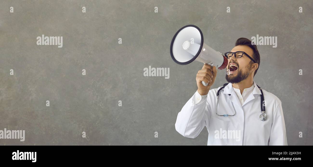 Doctor speaking in a megaphone, drawing attention and announcing some important news Stock Photo