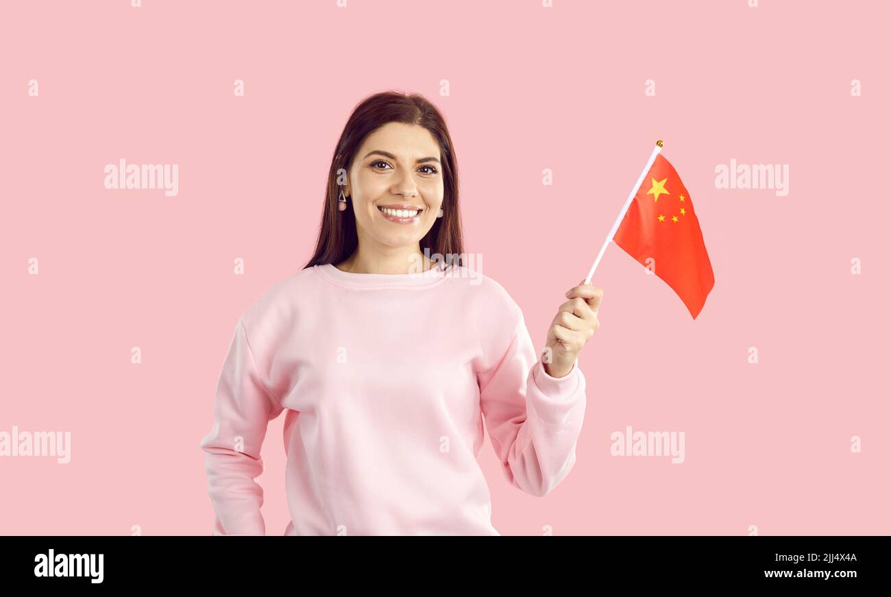 Smiling woman hold Chinese flag in hands Stock Photo